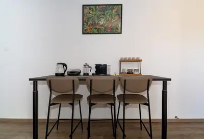 a black table with four chairs in front of a wall at City Centre Modern Boho Stay in Nicosia