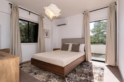 a bedroom with a bed and large windows at City Centre Modern Boho Stay in Nicosia