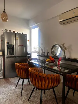 a kitchen with a table and chairs and a refrigerator at Makenzy 2 Bedrooms Apartment for rent in Larnaka