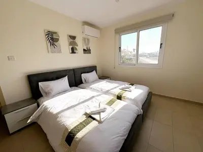 a large bed in a room with a window at Sunrise Palette Suites in Larnaka