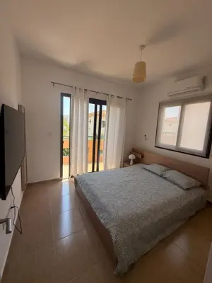 a bedroom with a bed and a flat screen tv at Dene Hollow kapparis in Paralimni