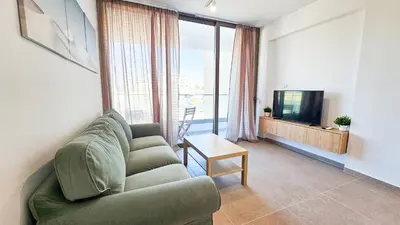 a living room with a couch and a television at Beachside Breeze Apartment in Larnaka