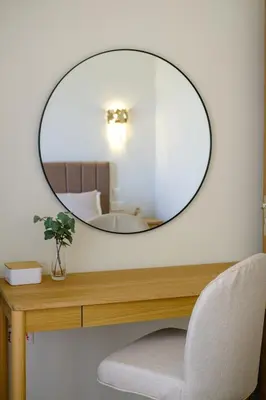 a mirror on top of a wooden table with a chair at The Serene Suite in Larnaka