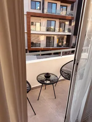 a balcony with three chairs and a table and a building at Cozy & Stylish 1Bedroom Apartment in Limassol