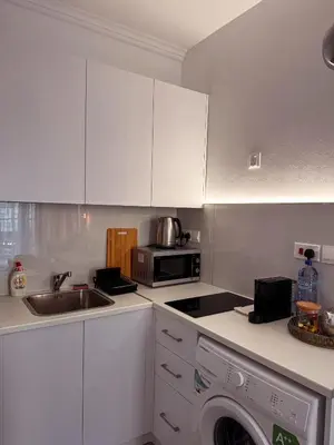 a kitchen with white cabinets and a sink and a microwave at Cozy & Stylish 1Bedroom Apartment in Limassol