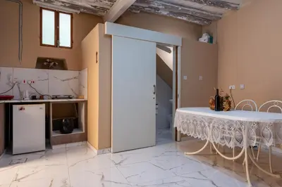 a kitchen with a white table and a counter at Traditional Stone House in Vouni, Quiet Stay with Courtyard & BBQ in Vouni