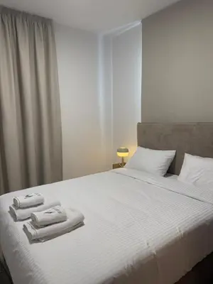 a bedroom with a white bed with towels on it at Kroisou Comfort Stay in Ayios Dhometios