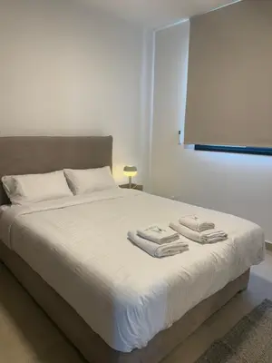a bedroom with a bed with two towels on it at Kroisou Comfort Stay in Ayios Dhometios