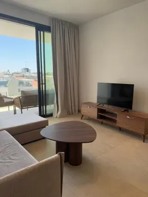 a living room with a couch and a tv and a table at Kroisou Comfort Stay in Ayios Dhometios