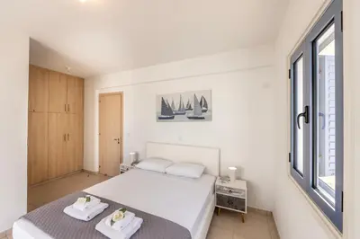 a white bedroom with a bed and two towels at Protaras Seaside Villa Protamare 32 in Protaras