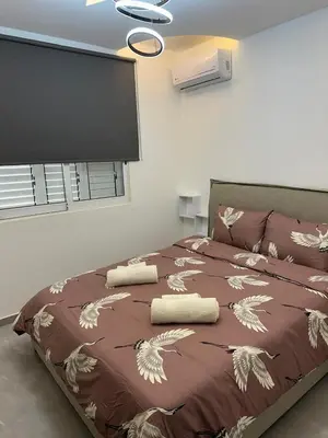 a bedroom with a bed with a brown comforter at Near Finikoudes beach 1 in Larnaka