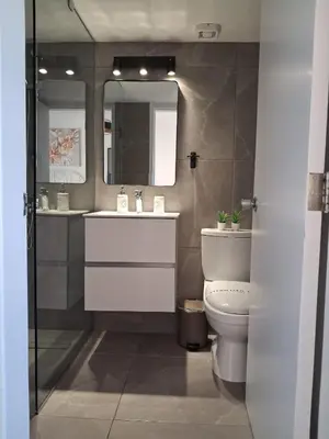 a bathroom with a toilet and a sink and a mirror at Lazuli Sea View & Pool Studio 303 in Larnaka
