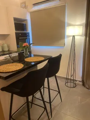 a kitchen with a table with chairs and a lamp at Lazuli Sea View & Pool Studio 303 in Larnaka
