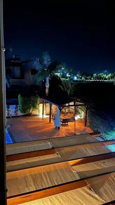 a table with an umbrella on a patio at night at Villa Porta Aurea in Ayia Napa