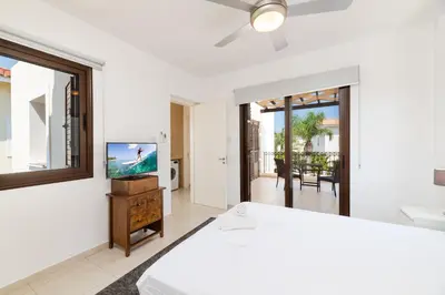 a bedroom with a bed and a flat screen tv at Villa Enaria Serene 3Bdr Retreat in Ayia Thekla in Ayia Napa