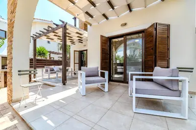 a patio with two chairs and a table at Villa Enaria Serene 3Bdr Retreat in Ayia Thekla in Ayia Napa