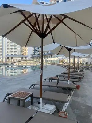 a row of tables and chairs with umbrellas on a patio at Riverside Life Residence in İskele