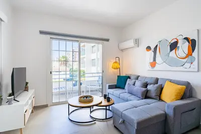 a living room with a couch and a tv at Destiny 1-Bedroom Apartment in Larnaka