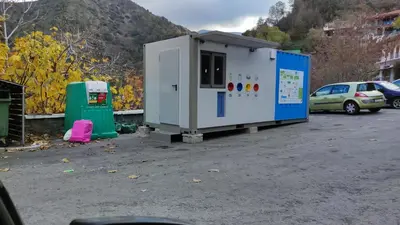a gas station and a car parked in a parking lot at Ambeli - Ambeloui in Kalopanayiotis