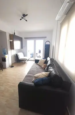 a person laying on a couch in a living room at Kennedy 5 apartman Ayia Napa in Ayia Napa