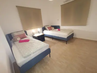 a room with two beds and two night stands at Kennedy 5 apartman Ayia Napa in Ayia Napa