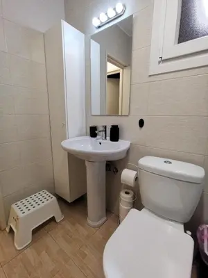 a bathroom with a white toilet and a sink at Kennedy 5 apartman Ayia Napa in Ayia Napa