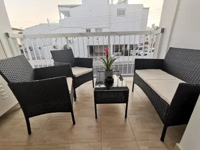 a balcony with chairs and a table and a bench at Kennedy 5 apartman Ayia Napa in Ayia Napa