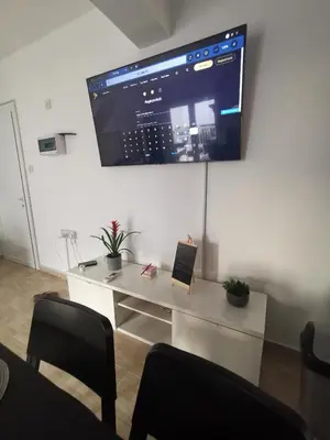 a room with a desk with a tv on the wall at Kennedy 5 apartman Ayia Napa in Ayia Napa