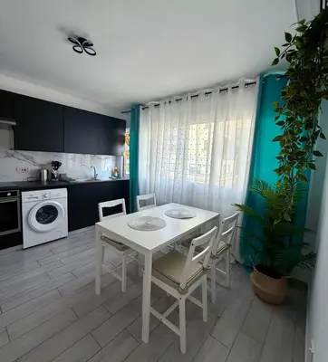 a kitchen with a white table and chairs in a room at Kypa rooms 50 steps to the beach in Larnaka
