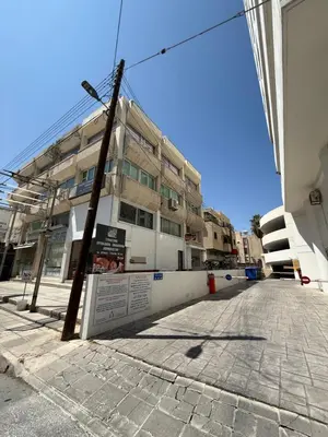 an empty street in front of a building at Kypa rooms 50 steps to the beach in Larnaka