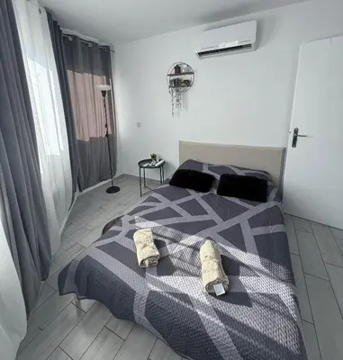 a bedroom with a bed with a black and white blanket at Kypa rooms 50 steps to the beach in Larnaka