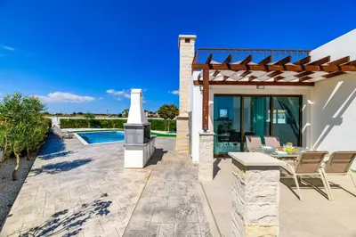 a patio with a table and chairs next to a house at Kymma Seaview #24 in Ayia Napa