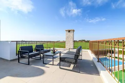 a patio with chairs and a table and a pool at Kymma Seaview #24 in Ayia Napa