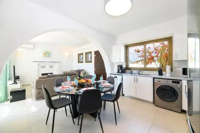 a kitchen and living room with a table and chairs at Kymma Seaview #24 in Ayia Napa
