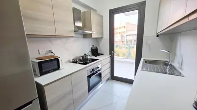 a small kitchen with a sink and a microwave at Poolside Lux Apartment in Larnaka