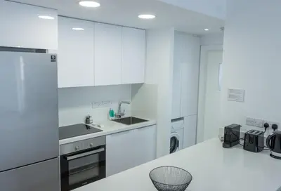 a kitchen with white cabinets and a white counter top at Stylish Modern City Center Stay in Nicosia