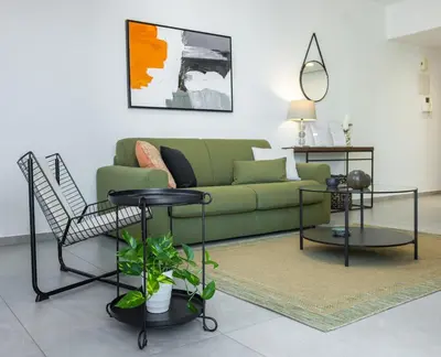 a living room with a green couch and a table at Stylish Modern City Center Stay in Nicosia