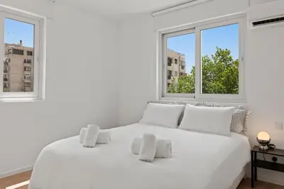 a white bed in a white room with two windows at Themelio Living 2-Bed Apartment Nicosia City Centre in Nicosia