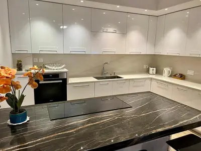 a large kitchen with white cabinets and a sink at Luxury Limassol Seaside Pool Suite in Limassol