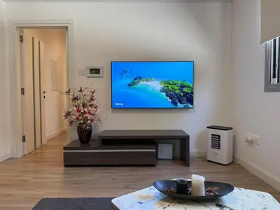 a living room with a flat screen tv on a wall at Luxury Limassol Seaside Pool Suite in Limassol