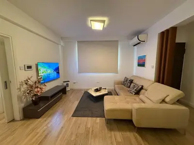 a living room with a couch and a flat screen tv at Luxury Limassol Seaside Pool Suite in Limassol