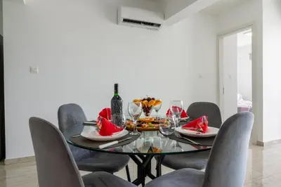 a dining room with a glass table and chairs at AURA Apt Modern 1BR in Central Limassol and Free Parking in Limassol