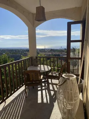a porch with a table and chairs on a balcony at Olive Tree House in Anoyira
