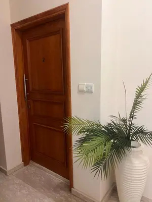 a plant in a white vase next to a door at Sandy Kisses in Larnaka