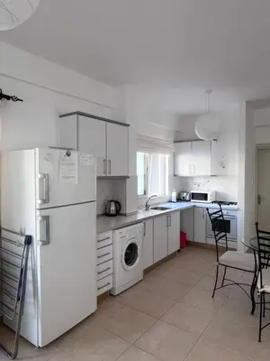 a white kitchen with a refrigerator and a dishwasher at Esentepe Turtle Bay Village - The Boho Breeze Holiday Home in Aglantzia