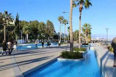a group of people walking in a street with palm trees at Bridge House 202-2BR Modern Apartment in Limassol