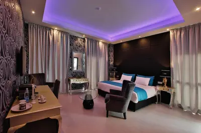 a hotel room with a bed and a desk and a table at The Josephine Boutique Hotel in Larnaka