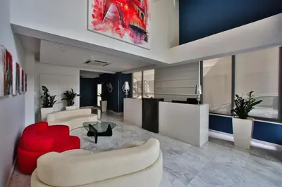 a living room with two chairs and a red couch at The Josephine Boutique Hotel in Larnaka