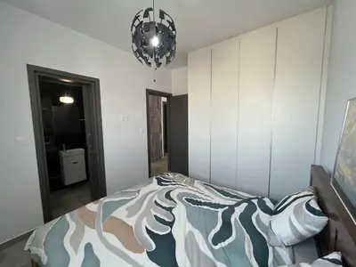 a bedroom with a bed and a chandelier at One Bedroom Penthouse Flat in Larnaka