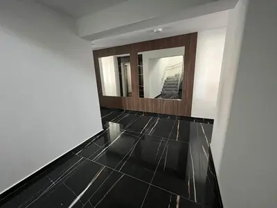 a hallway with a mirror and a black tile floor at One Bedroom Penthouse Flat in Larnaka